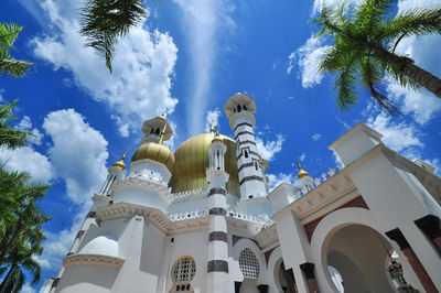 Low angle view of palm trees and buildings against sky