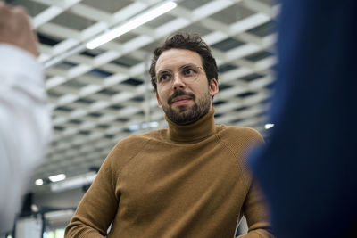 Businessman wearing eyeglasses standing with colleagues at industry