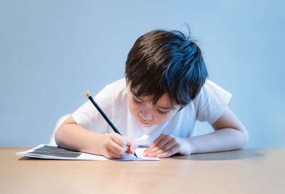 Cute boy studying at home