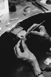 Cropped hands of jeweler making ring in workshop