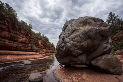 Rock formation on shore against sky