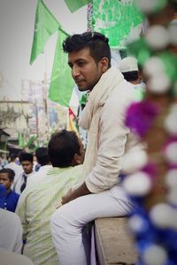 Side view of young man looking at camera
