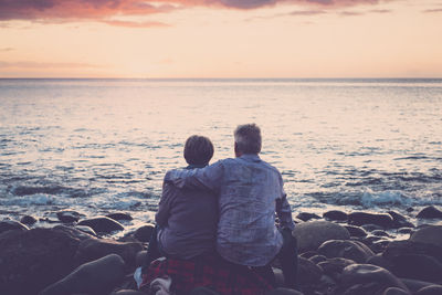 Senior couple by sea during sunset