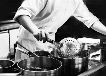 Midsection of man preparing food in restaurant