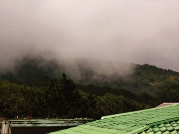 Scenic view of sea and mountain in foggy weather