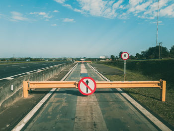 Road sign against sky