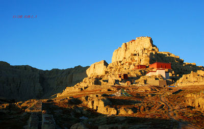 Rock formations on landscape against blue sky