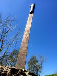 Low angle view of trees against clear blue sky