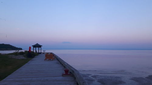 Pier over sea against sky during sunset