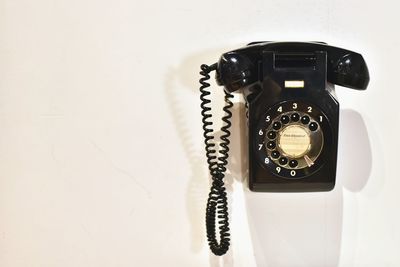 Close-up of telephone booth against wall