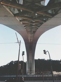 Road by bridge in city against sky