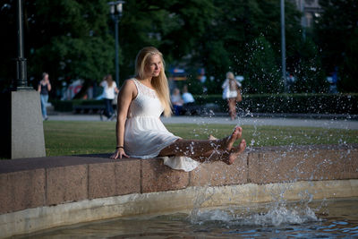 Woman dangling legs in swimming pool