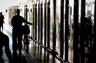 Rear view of silhouette men walking in building