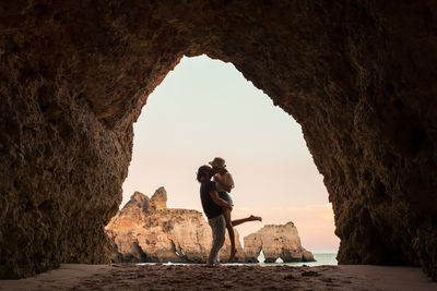Rear view of woman standing on rock formation