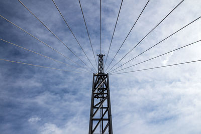 Low angle view of electricity pylon against sky