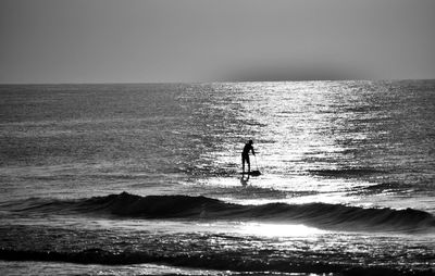 Silhouette man on beach against sky