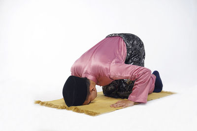 Midsection of man sitting on floor against white background