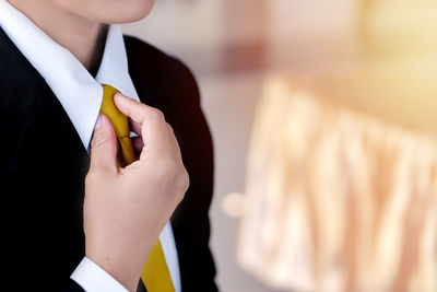 Midsection of businessman wearing suit standing at home