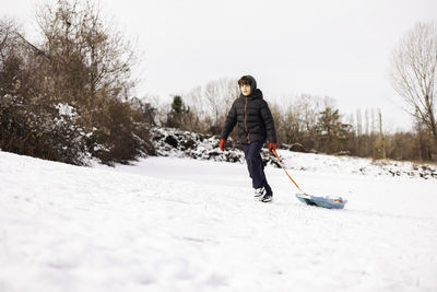 Rear view of man standing on snow covered landscape