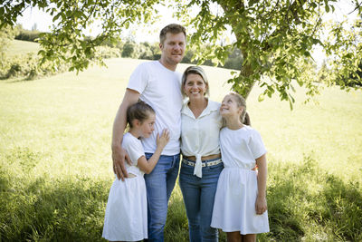 Portrait of siblings standing on field