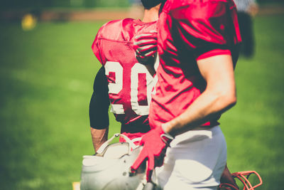 Midsection of men standing on playing field