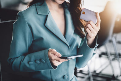 Midsection of woman using mobile phone