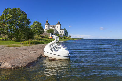 Built structure by sea against clear blue sky