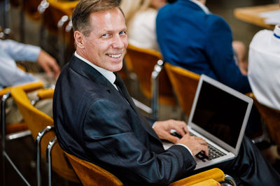 Midsection of businessman using laptop