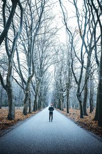 Rear view of man standing on road during autumn