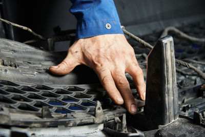 Hands of the master in cars and various car parts. car engine, bumper, metal parts of the car.