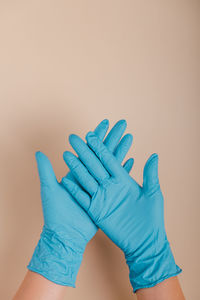 Close-up of hands against blue wall