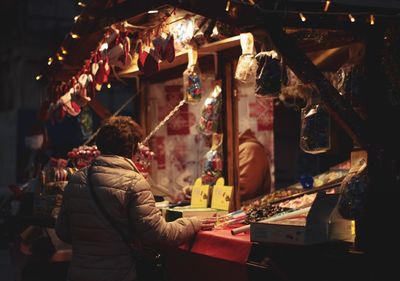 Person standing in market at night during christmas