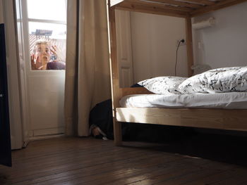 Portrait of curious young man seen through house door