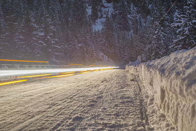 Light trails on snowy road at night during winter