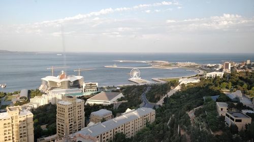 High angle view of buildings and sea against sky