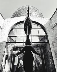 Rear view of man and woman standing against building