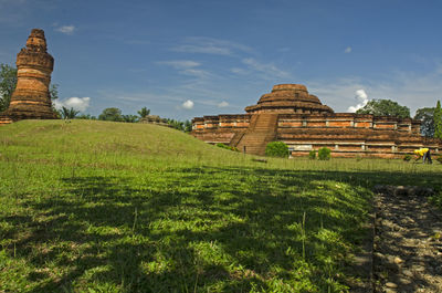 Built structure on field against cloudy sky