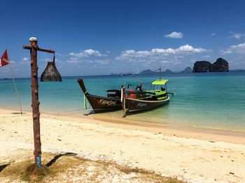 Boat moored on beach against sky