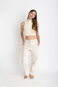 Portrait of young woman standing against white background