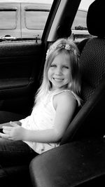 Portrait of happy girl sitting in car