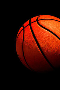 Close-up of basketball hoop against black background