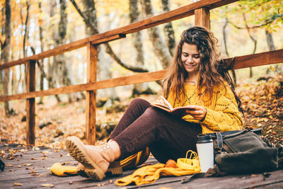 Young woman sitting on railing