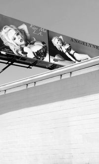 Low angle view of woman looking away against wall