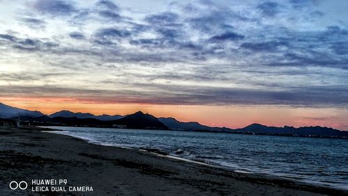 Scenic view of dramatic sky over mountains during sunset