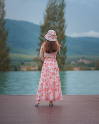 Rear view of girl standing on pink cloth