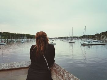 Rear view of woman standing by sea