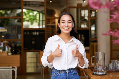 Portrait of young woman standing in cafe