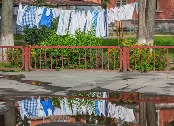 Clothes drying on railing by street against buildings