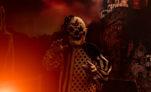 Man wearing mask against trees during halloween