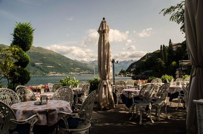 Chairs and tables at restaurant against sky